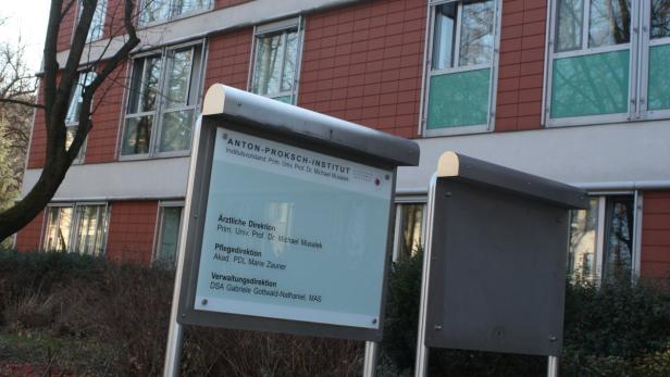Das Anton-Proksch-Institut mit Hinweisschildern vor einem Gebäude.
