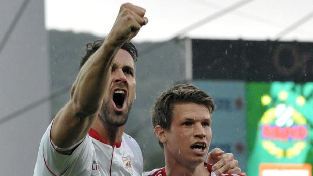 Zwei Fußballspieler jubeln auf dem Spielfeld.