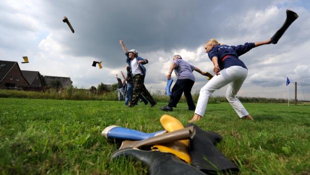 dpa/Angelika WarmuthSeeleute aus fünf verschiedenen Ländern und Mitarbeiter des Seemannsheim am Krayenkamp werfen am Dienstag (17.08.2010) in Hamburg Gummistiefel um die Wette. Das Seemannsheim hat die Seemänner, die zur Zeit im Hamburger Hafen Station Verrückte Wettbewerbe aus aller Welt