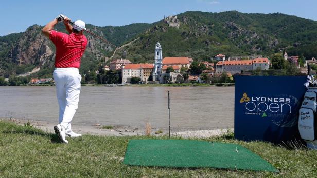 Ein Golfer schlägt den Ball beim Lyoness Open Turnier vor der Kulisse von Dürnstein.