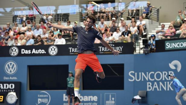 Ein Tennisspieler springt auf dem Platz, um einen Ball zu schlagen.