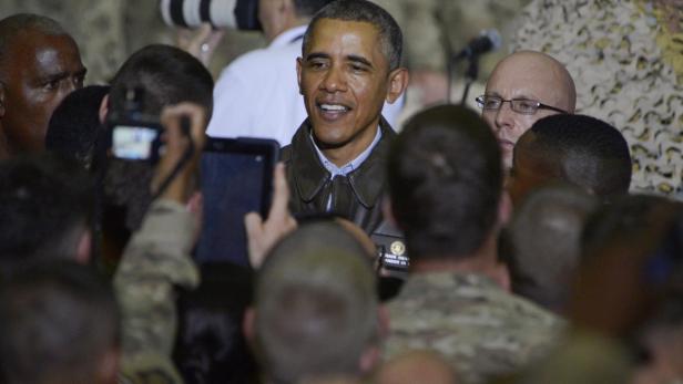 Barack Obama umringt von Menschen, die Fotos machen.