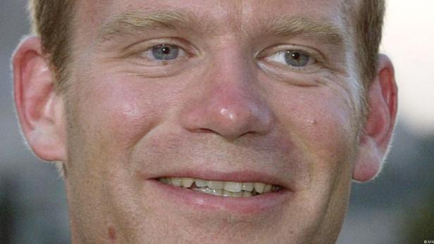 Nahaufnahme des Gesichts eines Mannes mit blonden Haaren und blauen Augen.