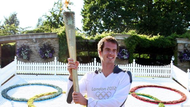 Andy Murray hält die olympische Fackel der Spiele 2012 in London.