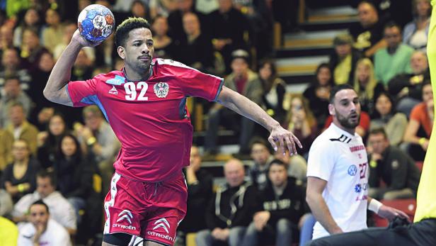 Ein Handballspieler mit der Nummer 92 wirft den Ball während eines Spiels.