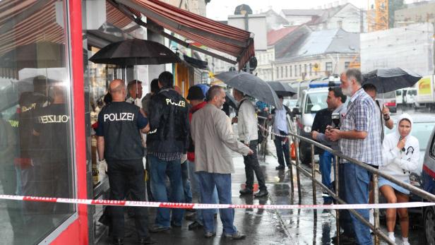 Polizei untersucht einen Tatort auf der Straße bei Regen.
