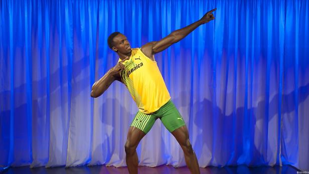 Usain Bolt posiert vor einem blauen Vorhang.