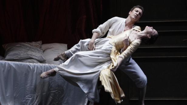 Ein Tänzer hält eine Tänzerin in einem theatralischen Pas de deux.