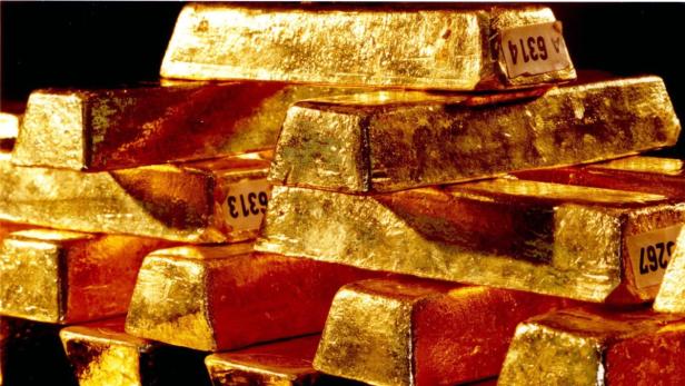 Ein Stapel glänzender Goldbarren mit aufgeklebten Etiketten.