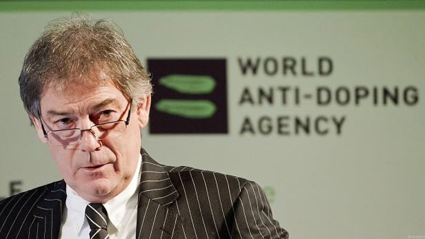 Ein Mann mit Brille und Anzug vor dem Logo der Welt-Anti-Doping-Agentur (WADA).