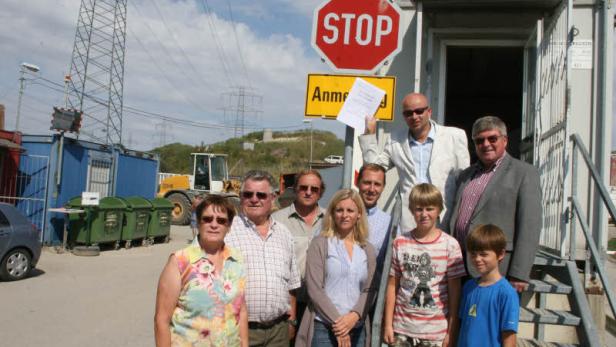 Eine Gruppe von Menschen steht vor einem Gebäude mit einem Stoppschild.