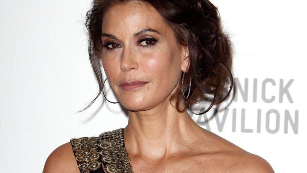 Ein Porträt von Teri Hatcher mit goldenem Kleid und Ohrringen.