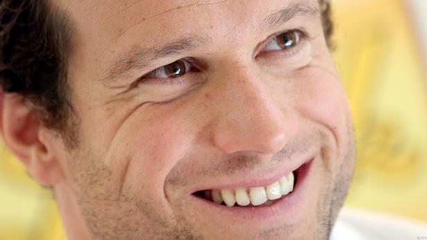 Nahaufnahme eines lächelnden Mannes mit braunen Augen.