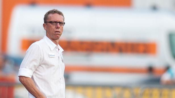 Ein Mann mit Brille und weißem Hemd steht vor einem Rettungswagen.