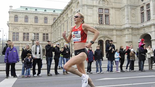 Eine Frau läuft einen Marathon vor der Wiener Staatsoper.