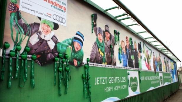 Eine Werbetafel für die Alpine Ski-Weltmeisterschaft 2013 in Schladming mit fröhlichen Kindern und dem Slogan „Jetzt geht's los! Hoppi Hoppi Hoppi!“.