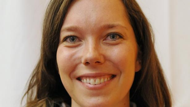 Porträt einer lächelnden Frau mit braunen Haaren.