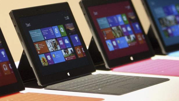 Mehrere Microsoft Surface Tablets mit farbigen Tastaturen stehen nebeneinander.