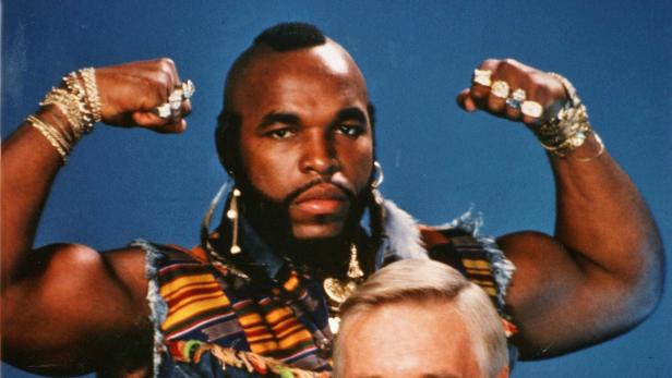 Mr. T mit Goldketten und Ringen zeigt seine Muskeln.