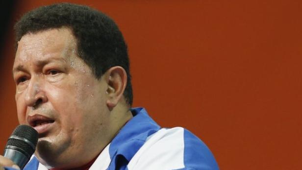 Hugo Chávez spricht bei einer Veranstaltung in ein Mikrofon.