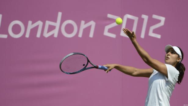 Eine Tennisspielerin serviert vor dem Hintergrund „London 2012“.