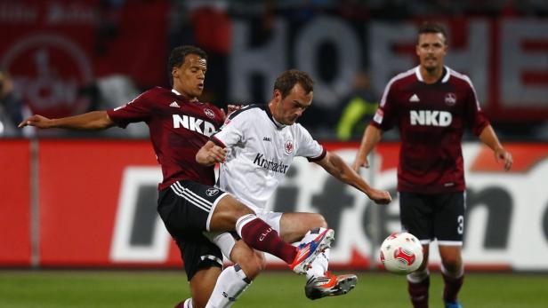 Zwei Fußballspieler kämpfen um den Ball während eines Spiels.