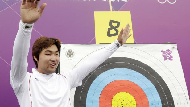 Ein koreanischer Bogenschütze jubelt vor einer Zielscheibe bei den Olympischen Spielen 2012 in London.