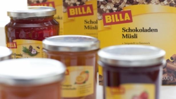 Gläser mit Marmelade und Honig sowie Packungen Schokoladenmüsli der Marke Billa.