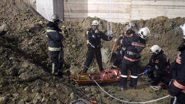 Einsatzkräfte der Feuerwehr bergen den Arbeiter, der auf einer U-Bahn-Baustelle im Bereich der zukünftigen U1 Station Troststraße von rund zwei Kubikmeter Erdreich verschüttet worden ist.