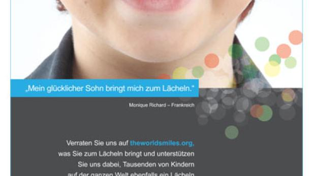 Ein lächelnder Junge mit Sommersprossen auf einem Werbeplakat für theworldsmiles.org.