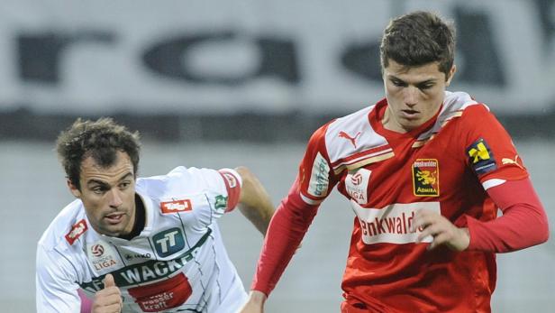 Zwei Fußballspieler in ihren Trikots während eines Spiels.