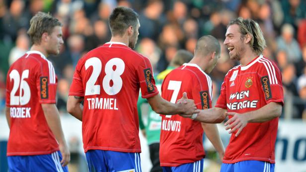 Fußballspieler von Austria Wien feiern auf dem Spielfeld.