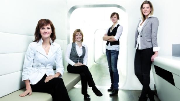 Vier Frauen posieren in einem hellen, modern gestalteten Raum.