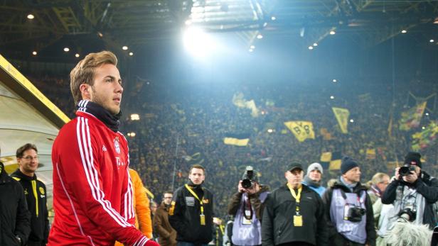Mario Götze im roten Bayern München Trainingsanzug vor der gelben Wand des Dortmunder Stadions.
