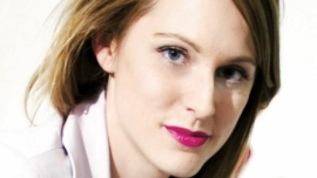 Porträt einer Frau mit blonden Haaren und pinkfarbenem Lippenstift.