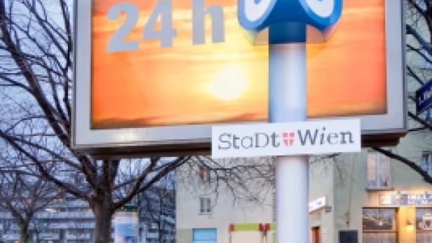 Ein U-Bahn-Symbol der Stadt Wien vor einer Werbetafel mit der Aufschrift „24 h“.