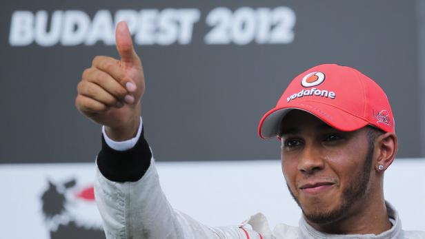 Lewis Hamilton mit roter Vodafone-Kappe gibt einen Daumen nach oben.