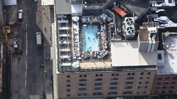 Blick von oben auf ein Hotel mit Pool und Restaurant auf dem Dach.
