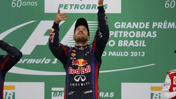 Sebastian Vettel feiert seinen Sieg beim Großen Preis von Brasilien 2013, zusammen mit anderen Fahrern auf dem Podium.
