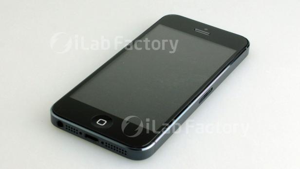 Ein schwarzes Smartphone liegt auf einem weißen Untergrund.