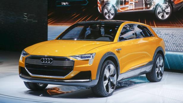 Ein gelber Audi e-tron Prototyp steht auf einer Bühne.