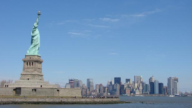 Die Freiheitsstatue mit der Skyline von New York im Hintergrund.