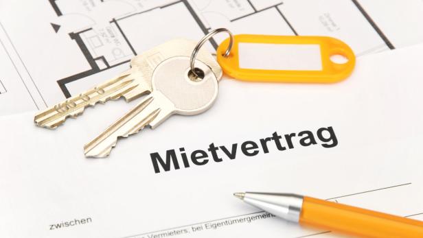 Ein Mietvertrag mit Schlüsseln und einem Stift liegt auf einem Tisch.