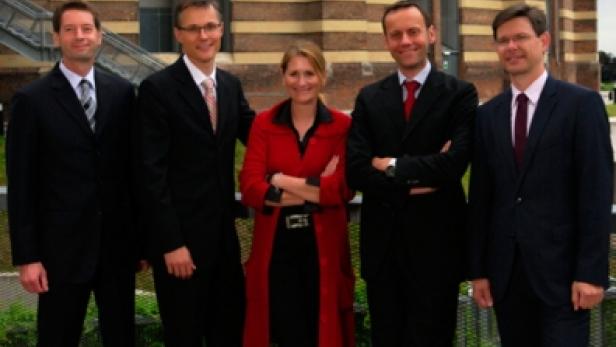 Eine Gruppe von fünf Führungskräften posiert vor einem Gebäude: Matthias Baldermann, Jan Trionow, Sabine Hogl, Thomas Malleschitz und Rudolf Schrefl.