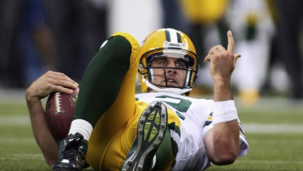 Ein Footballspieler der Green Bay Packers liegt auf dem Rasen und hält einen Ball.