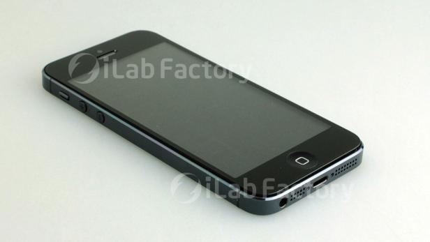 Ein schwarzes iPhone 5 liegt auf einer weißen Oberfläche.