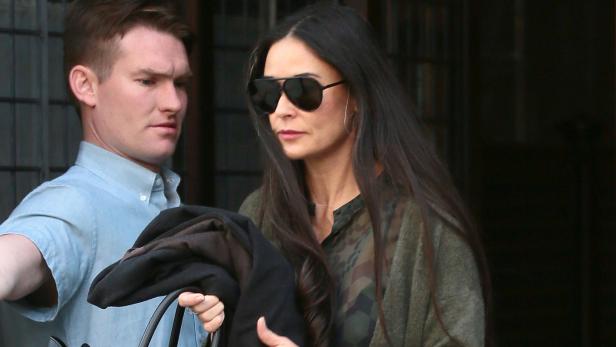 Demi Moore mit Sonnenbrille und Begleitung verlässt ein Gebäude.