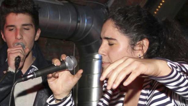 Ein Mann und eine Frau singen in Mikrofone.