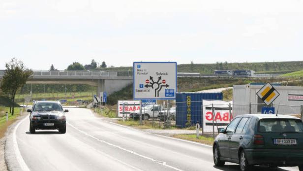 Ein Wegweiser zeigt die Richtungen nach Brno, Poysdorf, Schrick, Gaweinstal und Wien an einer Landstraße.