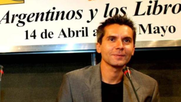 Ein Mann steht vor einem Banner mit der Aufschrift „Argentinos y los Libros“.